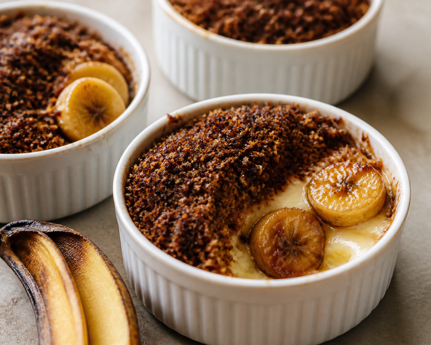 Cazuelitas tibias de plátano caramelizado y crema de vainilla con costra crujiente de coco y cacao