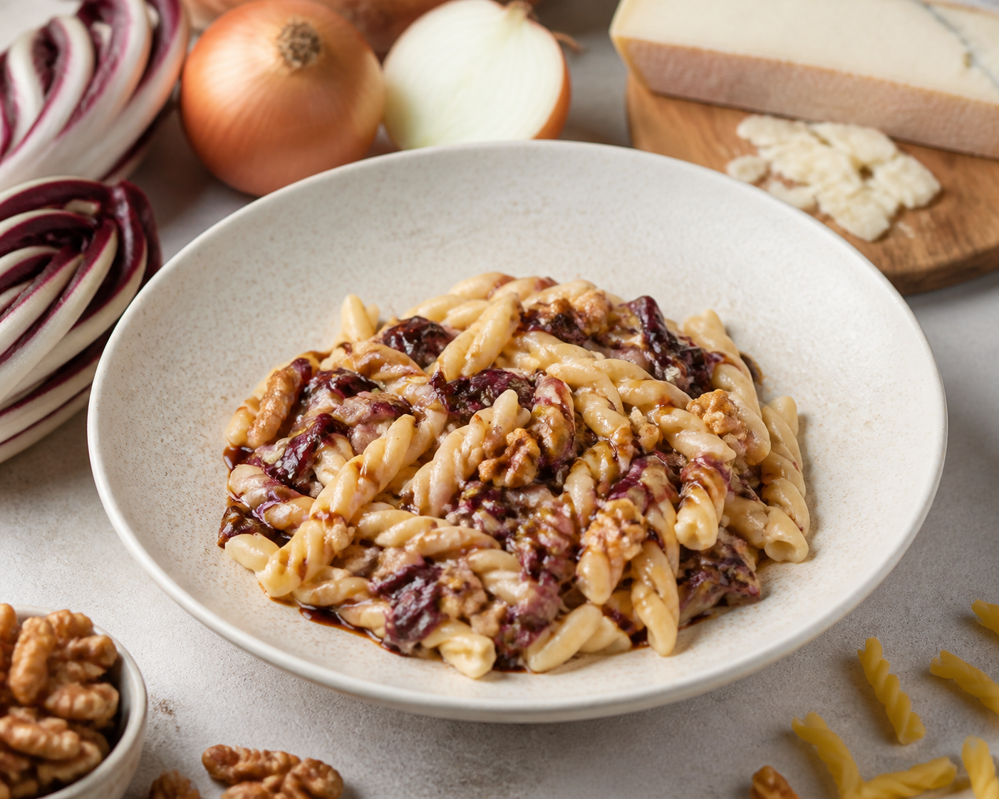 Gemelli cremosos de cebolla caramelizada, radicchio salteado y taleggio con nuez tostada y balsámico