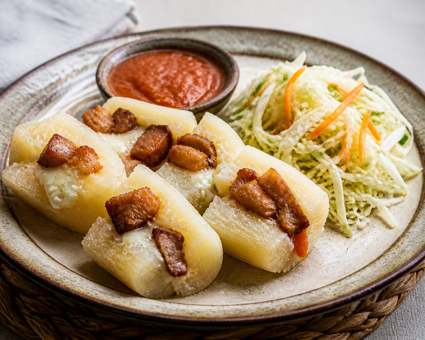 Yuca Salvadoreña Rellena de Quesillo y Chicharrón con Ensalada de Repollo y Salsa de Tomate Asado