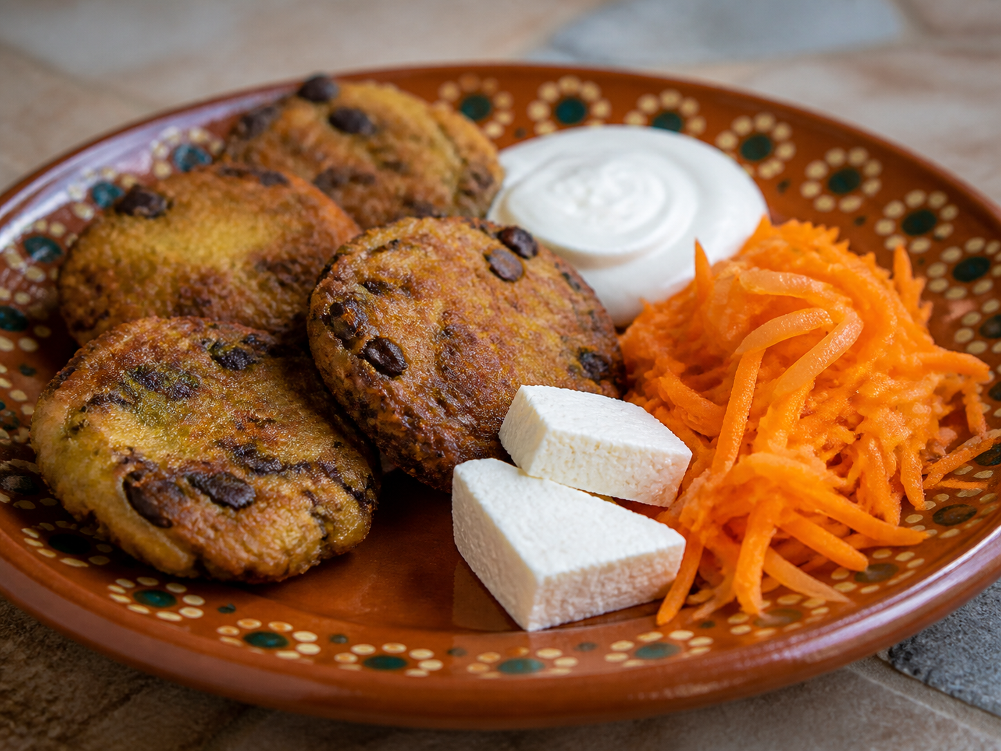 Torrejitas Salvadoreñas de Plátano Verde y Frijol Rojo con Crema de Ajo y Curtido de Zanahoria