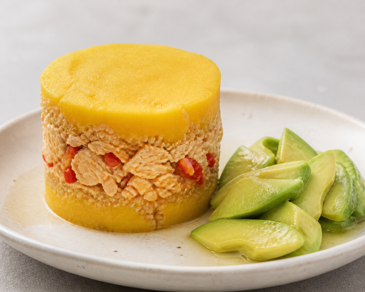 Causa Dorada de Quinua con Pollo al Rocoto y Ensalada de Palta