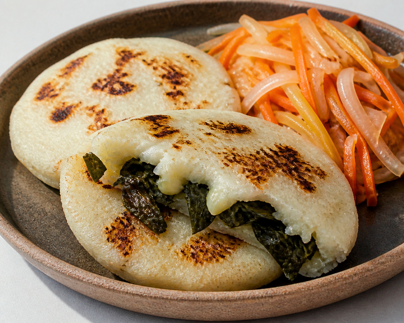 Pupusas de arroz con mora y quesillo ahumado, con curtido tibio de cebolla y zanahoria