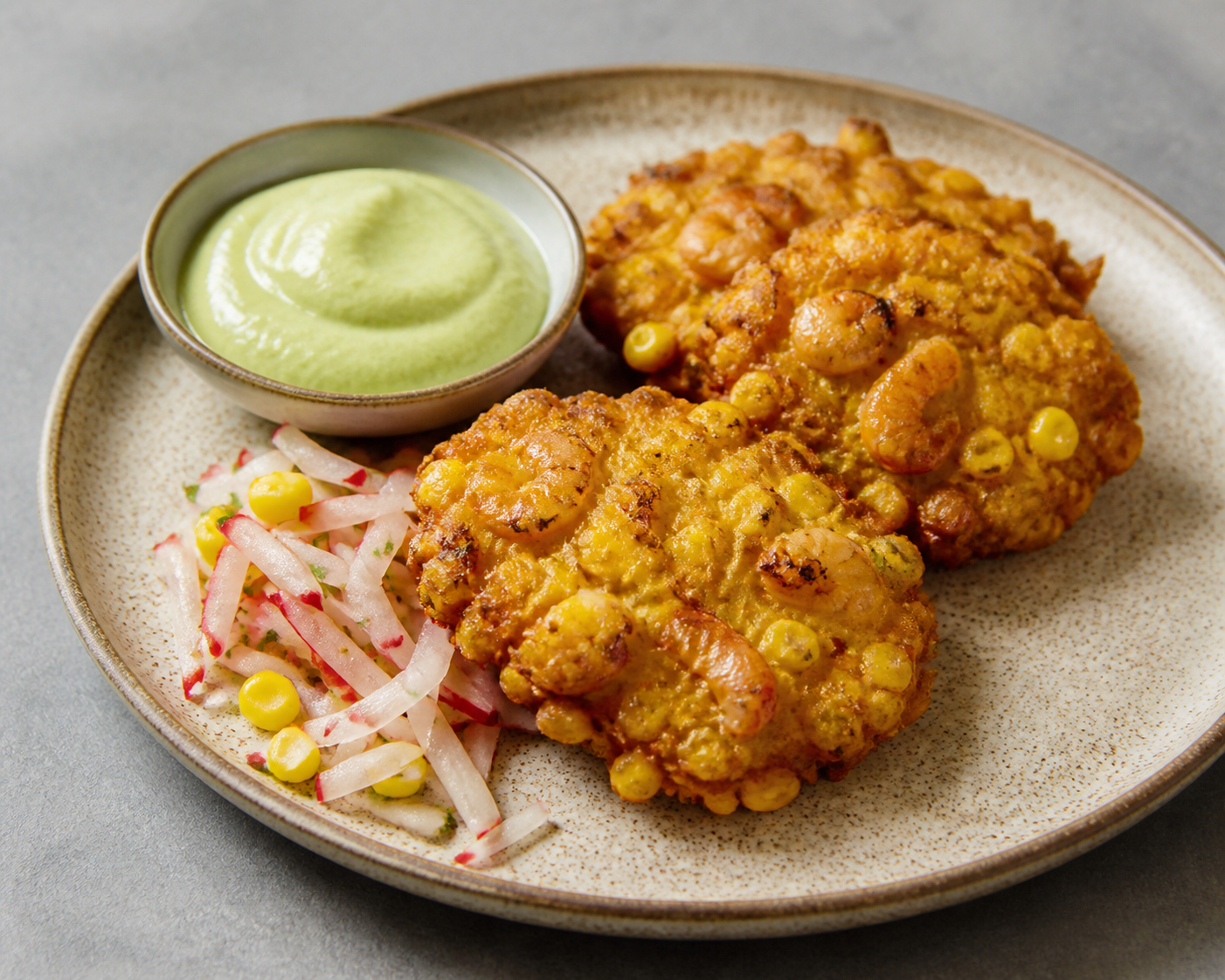 Salvadoran sweet corn and dried shrimp cakes with avocado crema and radish slaw