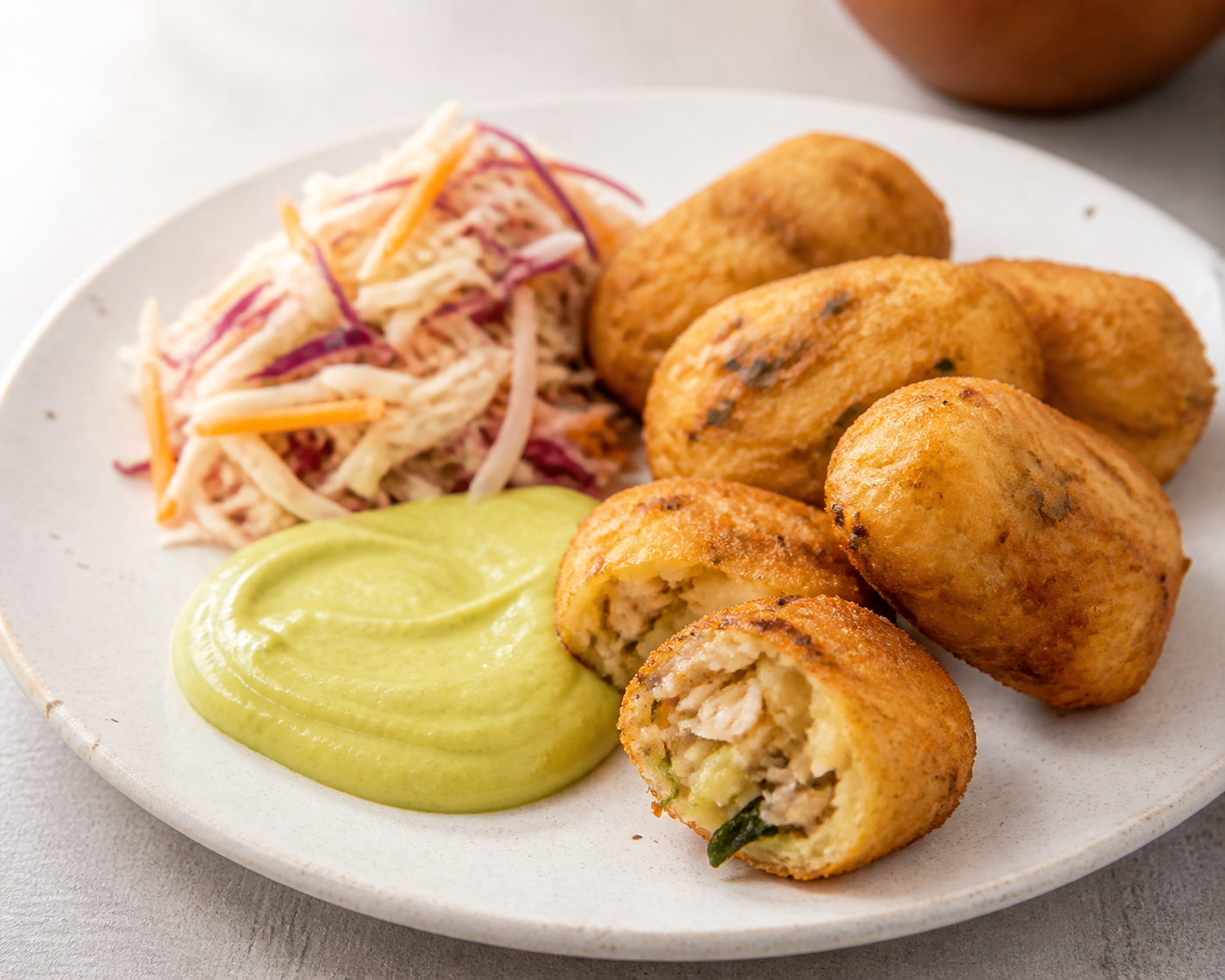 Salvadoran yuca and dried fish croquettes with avocado cream and citrus cabbage slaw