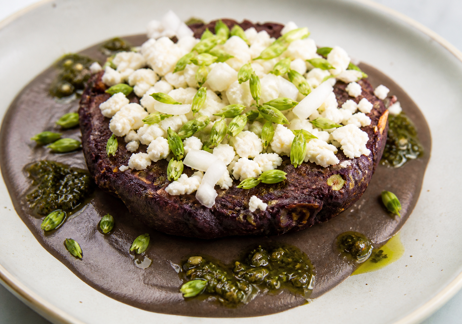 Salvadoran Purple Corn and Loroco Fritters with Fresh Curd, over Black Bean Cream and Roasted Chirmol