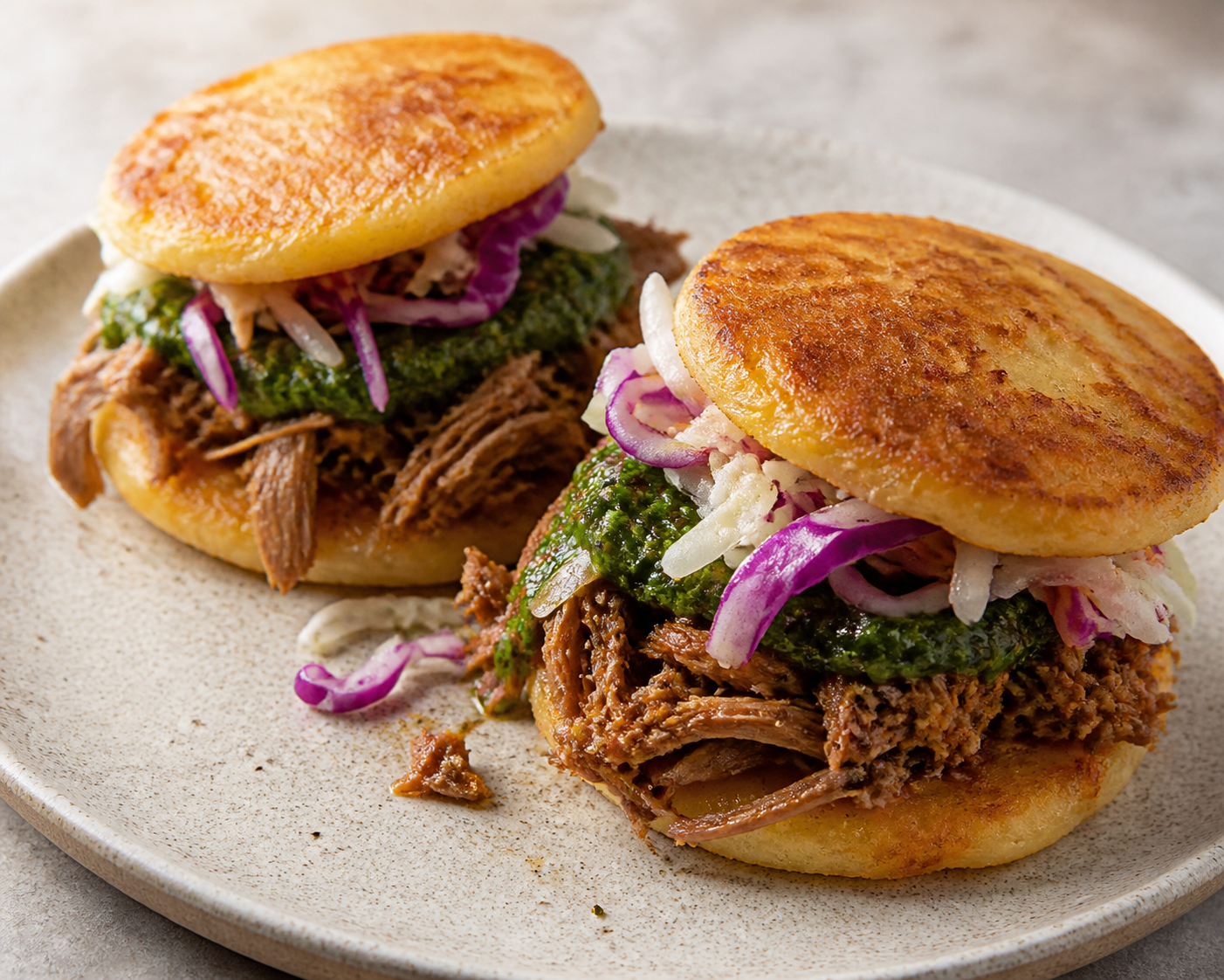 Arepas Rosti de Yuca con Pernil Desmechado al Papelón, Guasacaca de Hierbas y Ensalada Tibia de Repollo