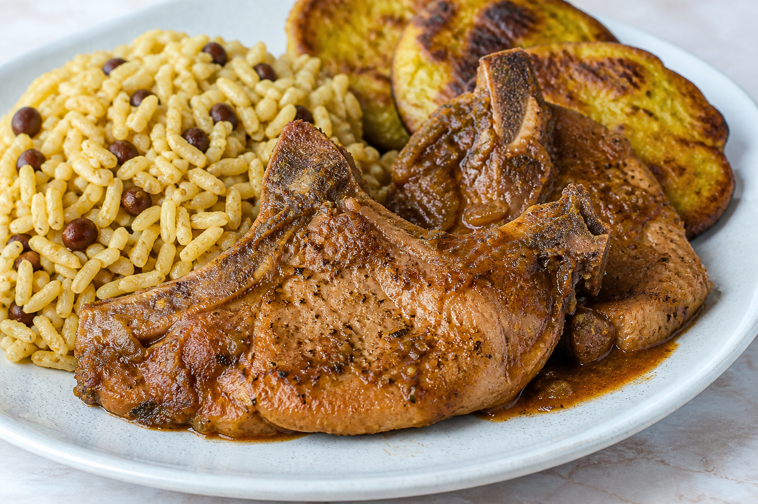 Chuletas de Cerdo Guisadas en Sofrito de Tamarindo con Arroz de Gandules y Costra de Plátano Verde
