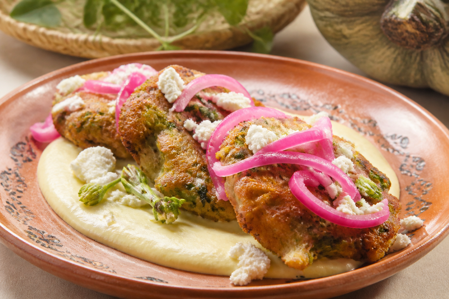 Buñuelos salvadoreños de ayote y loroco con crema de maíz tierno y cebolla morada al limón