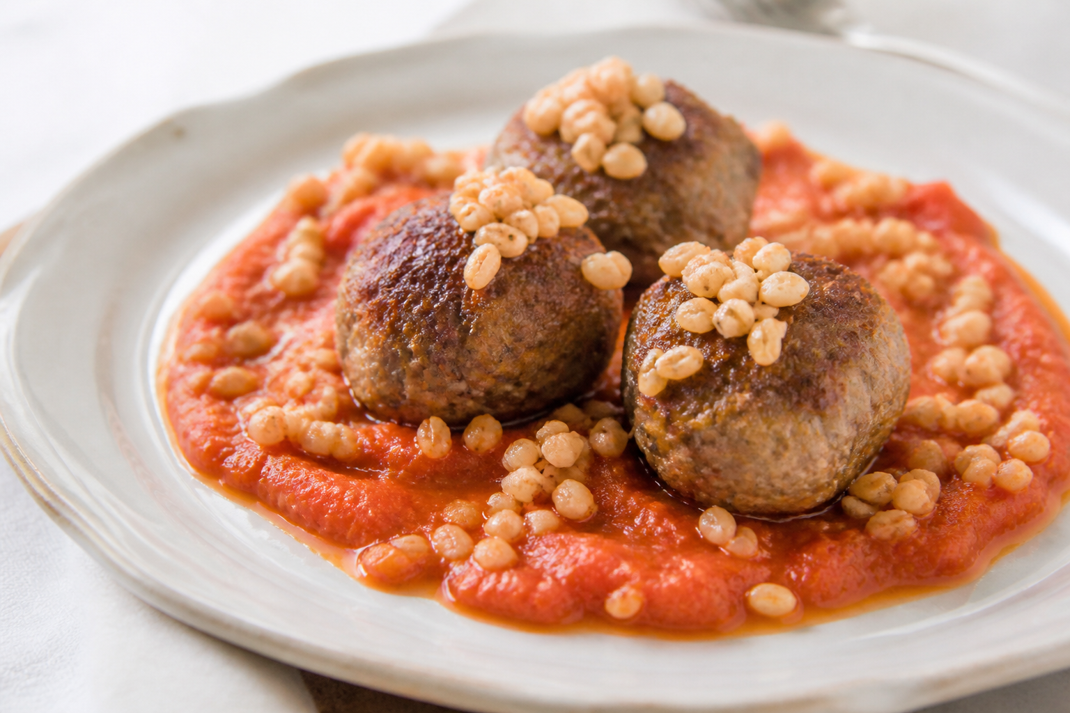 Albóndigas Criollas de Vacío y Ricota con Salsa de Morrón Asado y Trigo Tostado