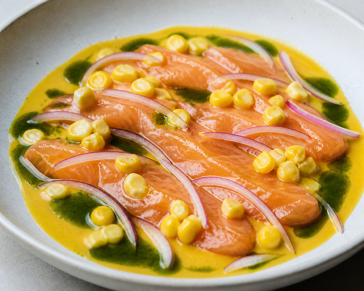 Tiradito tibio de trucha con crema de choclo al ají amarillo y aceite verde de huacatay