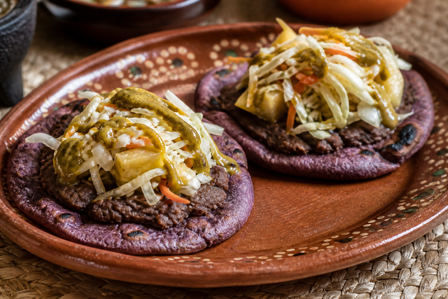 Pupusas abiertas salvadoreñas de maíz pujagua con frijol negro refrito, curtido de piña y salsa de chile guaque asado