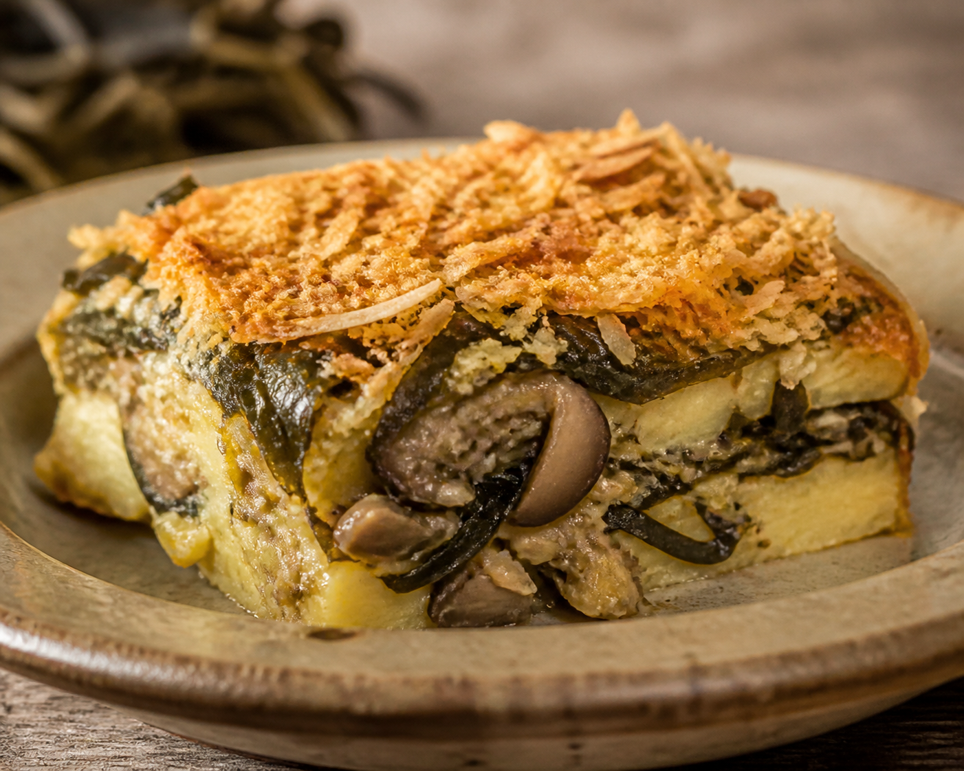 Pastel de Cochayuyo y Papas Doradas con Pino de Champiñones, Cebolla Caramelizada y Costra de Chuchoca