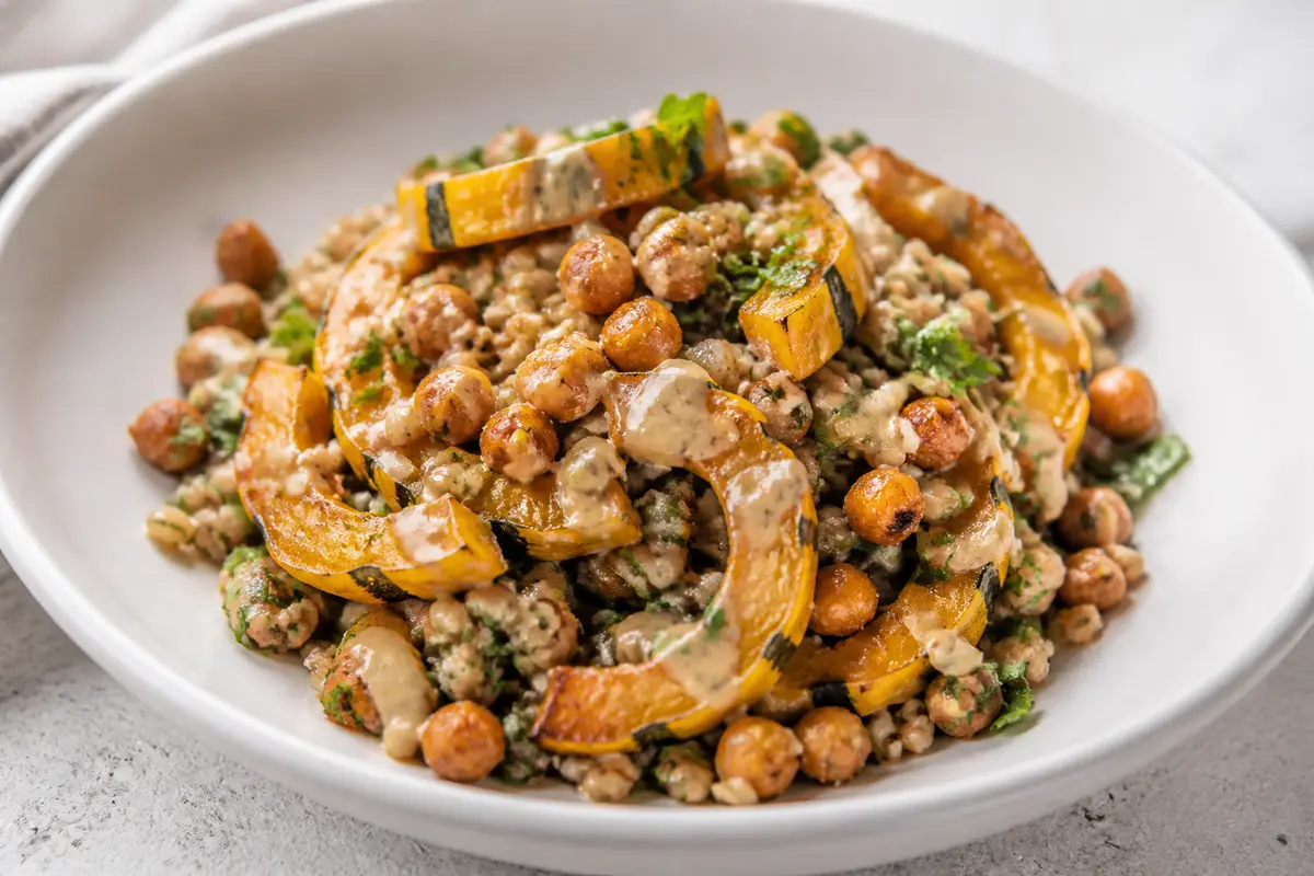 Calabaza delicata asada con farro de hierbas, garbanzos crujientes y vinagreta de arce y tahini