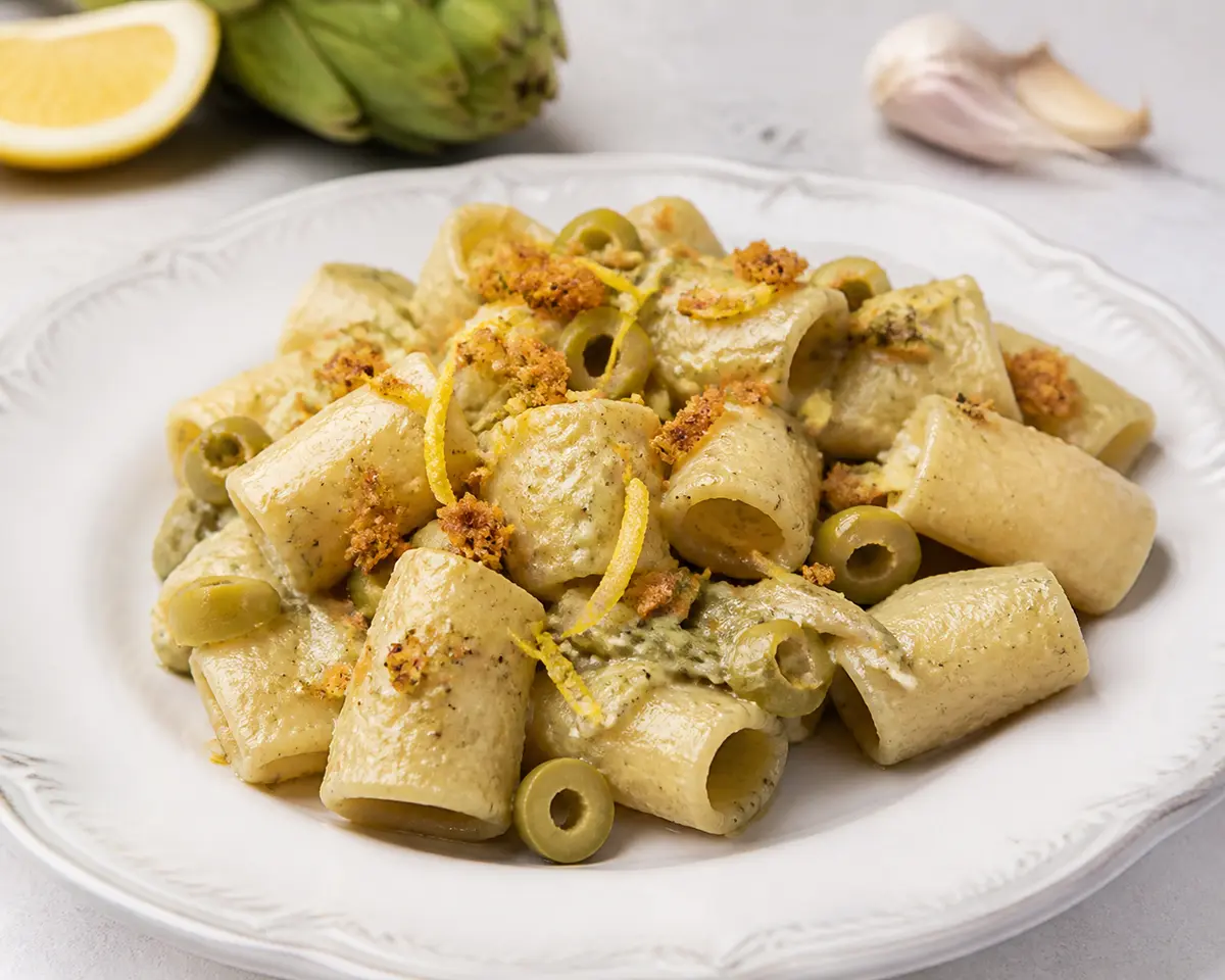 Paccheri al horno con crema de alcachofa, aceitunas verdes, limón y costra de focaccia crujiente