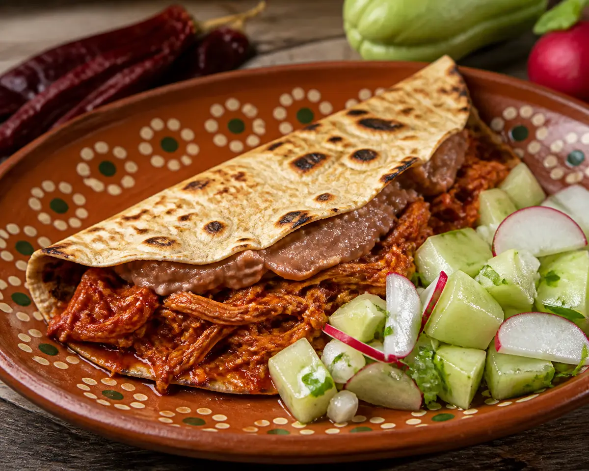Folded Tlayuda with Guajillo Chicken, Refried Pot Beans, and Warm Chayote Radish Salad