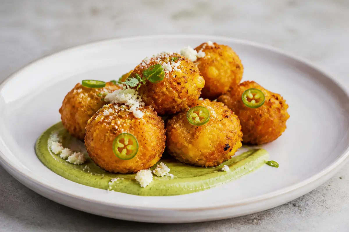 Crispy corn, panela and jalapeño bites with roasted lime avocado cream