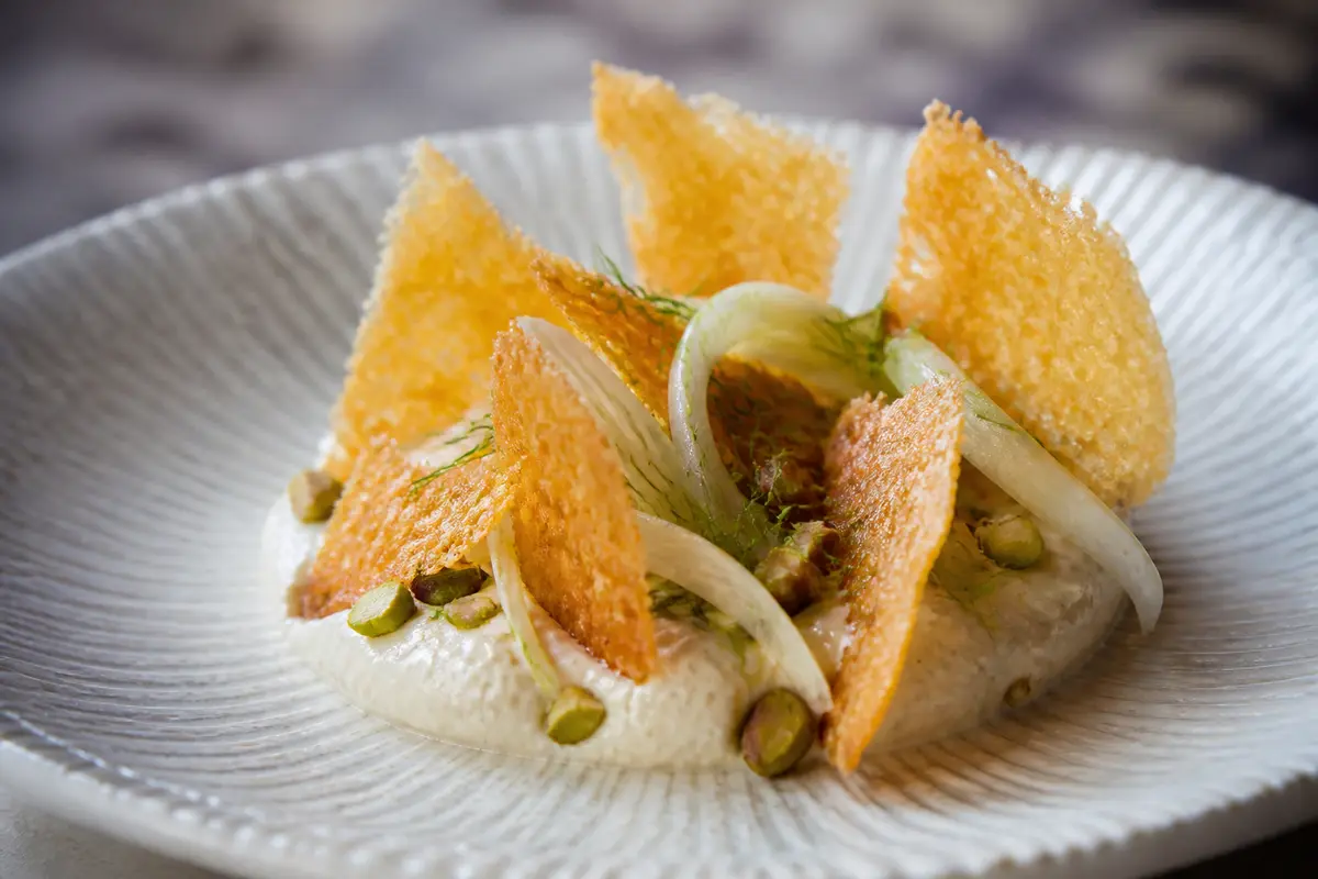 Tejas de provolone con crema de alcachofa al limón, hinojo crujiente y pistacho