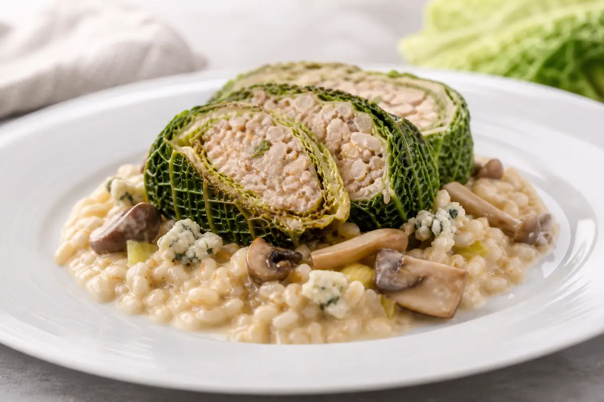Roulade de col savoy con cebada cremosa, setas al jerez y salsa de queso azul suave
