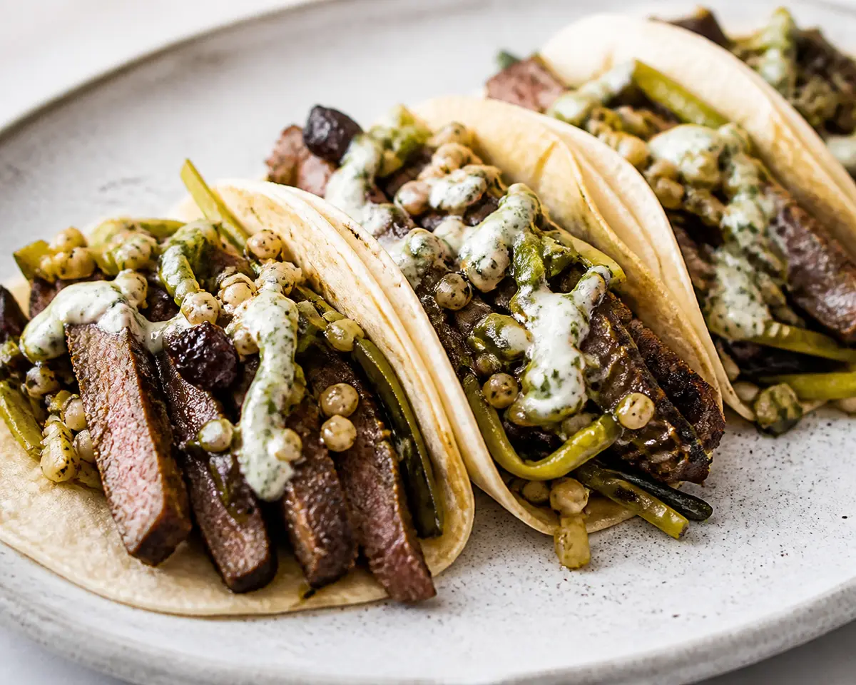Steak Tacos with Ancho Chile and Toasted Barley, Corn-Lime Crema, and Crisp Nopal Salad